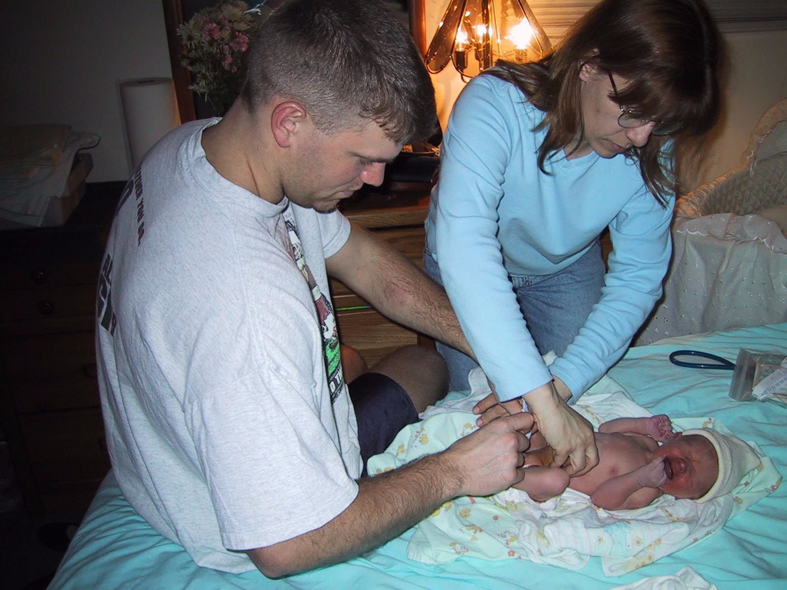 Laurie and a new Dad diapering and dressing the baby after the newborn exam.